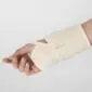 Cream merino wool wrist support wrap with a thumb loop worn on a person's hand and wrist.