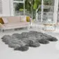 Large octo grey sheepskin rug with a thick, textured pile and natural scalloped edges on a white floor.