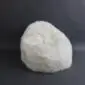 Ivory sheepskin bean bag with a thick, textured wool surface.