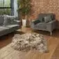 Long-haired taupe Icelandic sheepskin rug with natural irregular edges on a wooden floor.