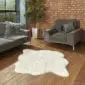 Hide Rugs_Lifestyle_0020 A large ivory shorn Icelandic sheepskin rug with an irregular natural shape on a wooden floor.
