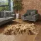 Long-haired rusty brown Icelandic sheepskin rug with three joined skins on a wooden floor.