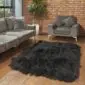 Hide Rugs_Lifestyle_0085 Large black Icelandic sheepskin rug with long, shaggy wool on a wooden floor.
