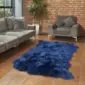 Large navy blue four-skin sheepskin rug with a thick, textured pile on a wooden floor.