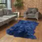 Large navy blue four-skin sheepskin rug with a thick, textured wool pile on a wooden floor.