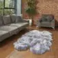 Large steel grey quad sheepskin rug with a thick, fluffy texture and natural scalloped edges on a wooden floor.