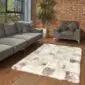 Rectangular shorn Icelandic sheepskin patchwork rug in cream, grey and brown tones on a wooden floor.