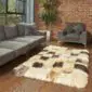 Rectangular patchwork sheepskin rug featuring mixed cream, tan, and dark brown natural wool squares.