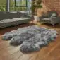 Large grey sexto sheepskin rug with a thick, textured pile and natural scalloped edges on a wooden floor.