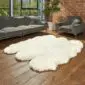 Hide Rugs_Lifestyle_0313 Large ivory sheepskin rug with a natural scalloped edge on a wooden floor.