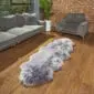 Long, steel grey double sheepskin rug with a thick, fluffy texture and natural scalloped edges on a wooden floor.