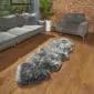 Hide Rugs_Lifestyle_0496 Long, grey double sheepskin rug with a thick, textured wool pile and natural curved edges on a wooden floor.