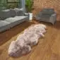 Long, multi-tonal grey and cream Paco sheepskin rug with a thick, textured pile on a wooden floor.