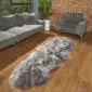 Long, double-length Icelandic sheepskin rug with thick, shaggy grey and white wool on a wooden floor.