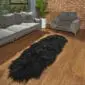 Hide Rugs_Lifestyle_0543 A long, black double Icelandic sheepskin rug with thick, shaggy wool on a wooden floor.
