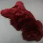 IMG_0059 Merlot red sheepskin rug with thick, textured wool pile and natural organic shape.