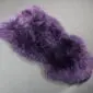 IMG_0113 A thick, textured purple sheepskin rug with an irregular natural shape and long wool fibres.