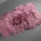 IMG_0904 Long-haired Icelandic sheepskin rug in dusty rose pink with a natural, shaggy texture.
