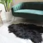 Natural black Icelandic sheepskin rug with long, shaggy wool pile and an irregular organic shape.