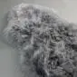 Close up of a grey sheepskin rug with long, curly wool fibres.
