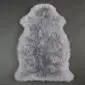 Steel grey sheepskin rug with a natural pelt shape and thick, textured wool pile.