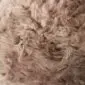 Close-up of a thick, curly Sexto Paco sheepskin rug in a natural taupe colour.