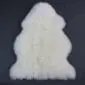 Natural ivory white sheepskin rug with thick, fluffy wool and an irregular organic shape .