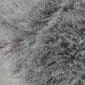 IMG_3512 Close-up of a steel grey Mongolian lambskin rug with long, curly wool fibres.