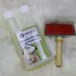 Sheepskin rug care set featuring a bottle of wool shampoo and a metal slicker brush with a wooden handle.