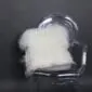 Square ivory Icelandic sheepskin cushion with long, shaggy wool texture resting on a .