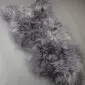 Long-haired Icelandic sheepskin rug in mottled grey and white tones with a natural organic shape. detail view