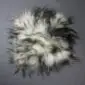 Circular Icelandic sheepskin pad with long, shaggy wool in cream and dark grey tones.