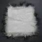 Square Icelandic sheepskin pad with long white wool and dark black tips.