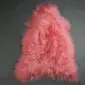 Long-haired Icelandic sheepskin rug in light coral pink with a natural pelt shape.