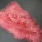 Long-haired Icelandic sheepskin rug in light coral pink with a natural organic shape.