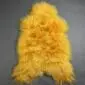 Long-haired golden yellow Icelandic sheepskin rug with a natural, irregular shape and thick, shaggy wool texture.
