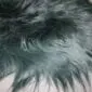 Close-up of a bottle green Icelandic sheepskin rug with long, thick, natural wool fibres.