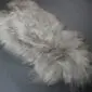 Long-haired Icelandic sheepskin rug in a natural linen grey tone with a shaggy texture.