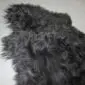 Long-haired black Icelandic sheepskin rug with a natural, irregular shape and thick, textured wool.