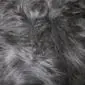 Close-up of a black Icelandic sheepskin rug showing long, thick, textured wool fibres.