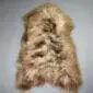 Long-haired Icelandic sheepskin rug in a rusty brown and tan colour with a natural hide shape.