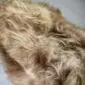 Long-haired Icelandic sheepskin rug in a rusty brown and cream colour with a natural shaggy texture.