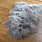 Long-haired grey Icelandic sheepskin rug with a natural organic shape on a wooden floor.