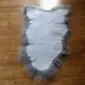 Small grey Icelandic sheepskin rug with long, natural wool fibres and an irregular organic shape.