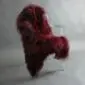 Long-haired burgundy red Icelandic sheepskin rug laid flat.
