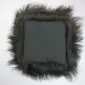 Reverse side of a black Icelandic sheepskin cushion showing a grey fabric backing and long shaggy wool trim.