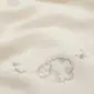 Close-up of an ivory merino wool blanket featuring a small embroidered sheep design.