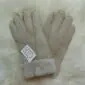 Beige suede sheepskin gloves with visible stitching and thick wool-lined cuffs.