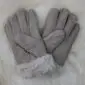 A pair of grey suede sheepskin gloves with cream wool lining visible at the cuffs.