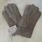 A pair of light ash grey suede sheepskin gloves for children featuring visible stitching and folded cuffs.